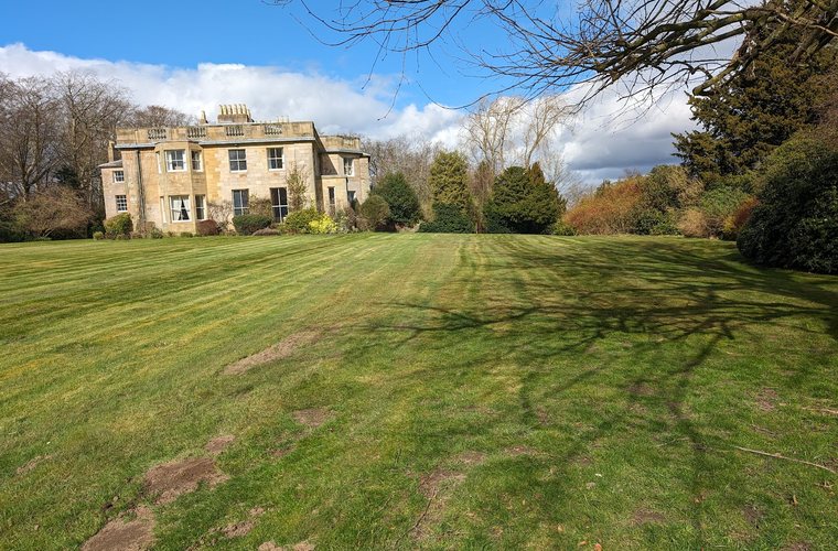 Striped lawns maintained across a country house estate