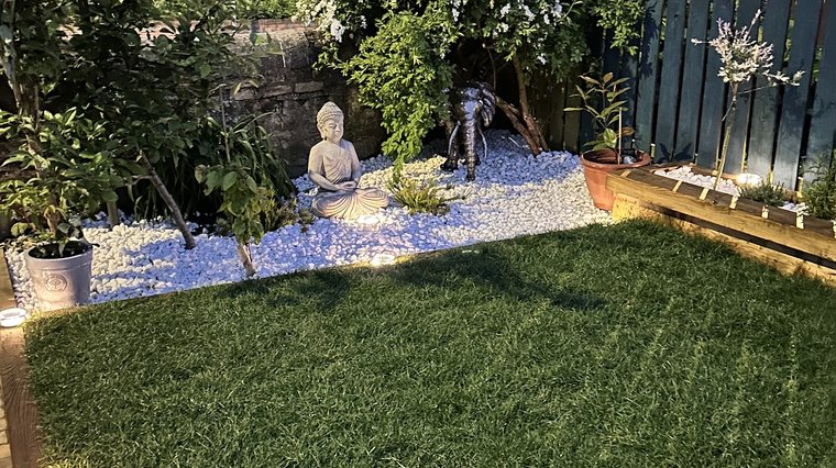 Planted borders and clipped shrubs beside a lawn